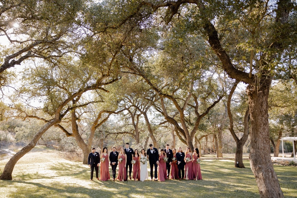 Wedding party walking in oak tree grove