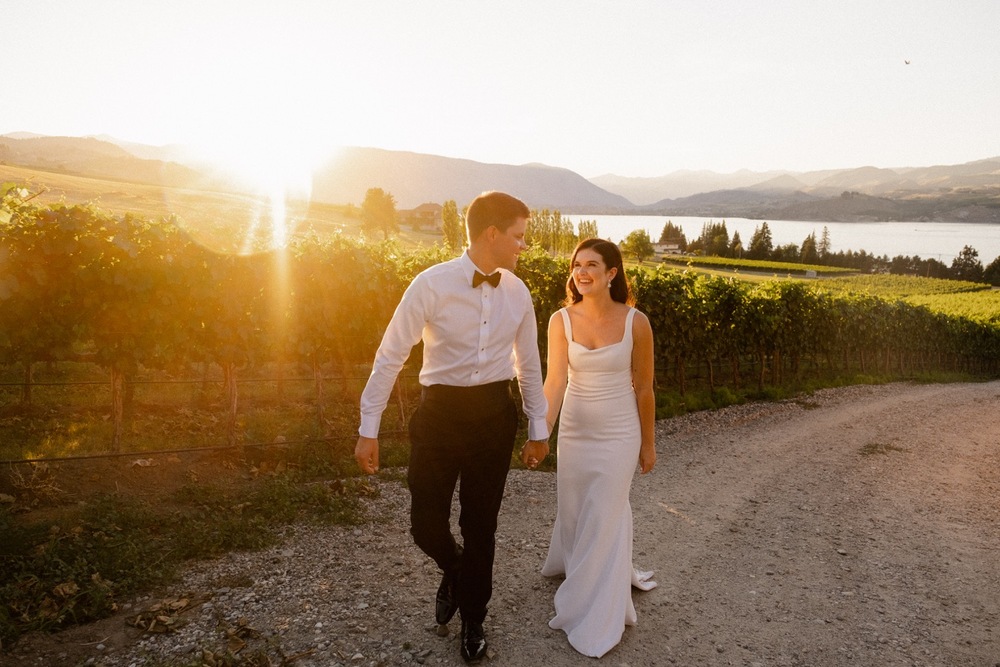 Couple walks together at sunset in a vineyard