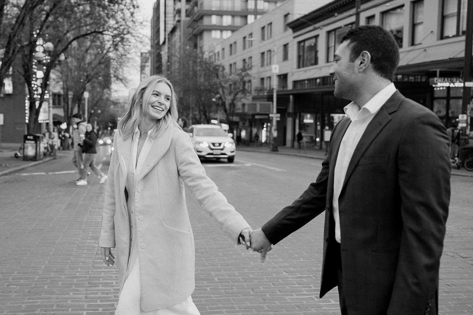 couple walks hand in hand during city engagement session