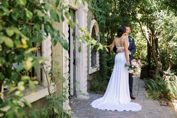 bride and groom stand together in a garden at the Corson building