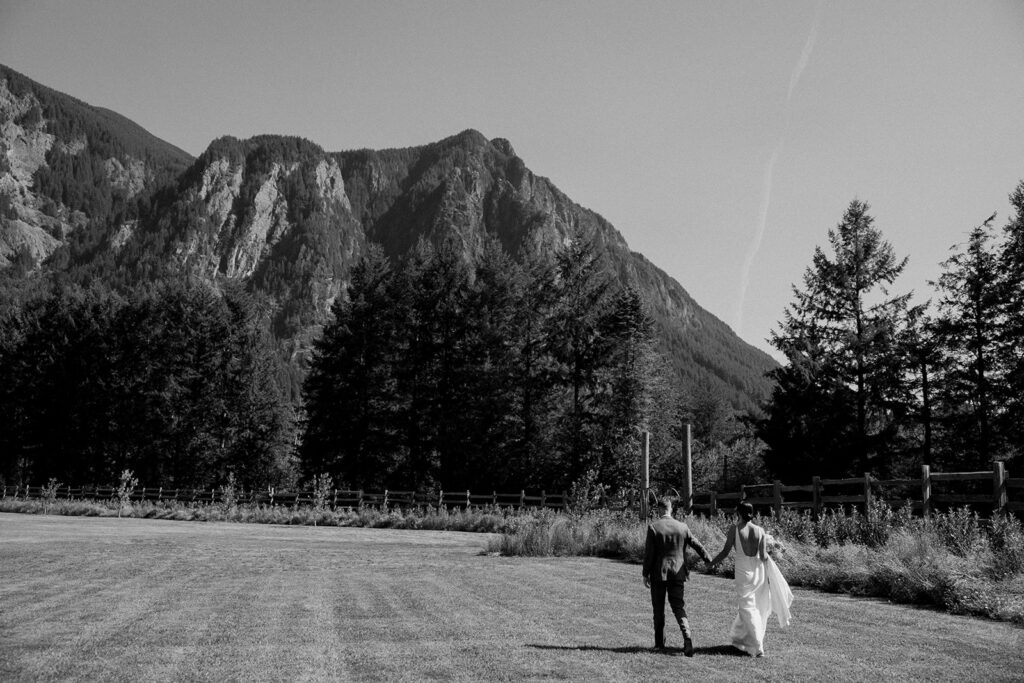 bride and groom walk across field